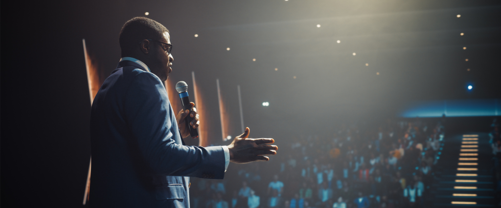 African Businessman Speaking at a Business Conference. Public Speaker Sharing Professional Knowledge and Leadership Insights. Shot from Behind. Chapter Resource Center | Speakers Bureau | Feature image